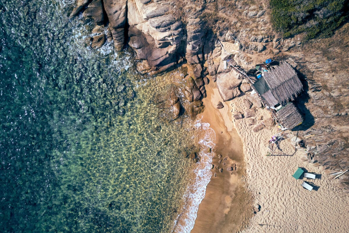 Man in hammock on a beautiful beach aerial view drone shot, Spain