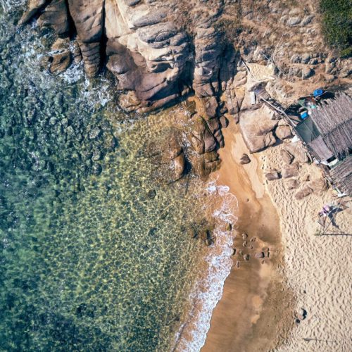 Man in hammock on a beautiful beach aerial view drone shot, Spain