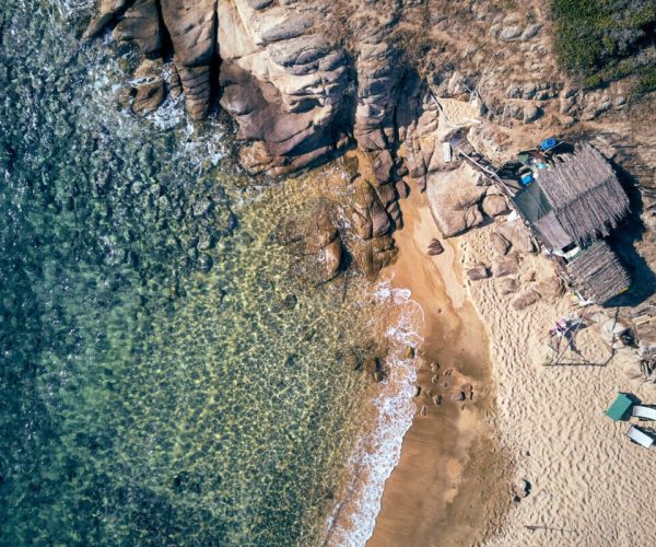 Man in hammock on a beautiful beach aerial view drone shot, Spain