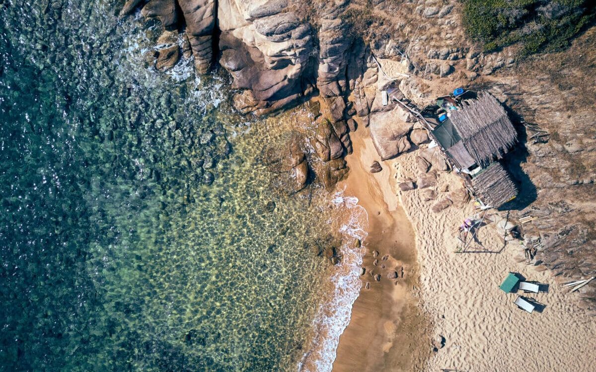 Man in hammock on a beautiful beach aerial view drone shot, Spain